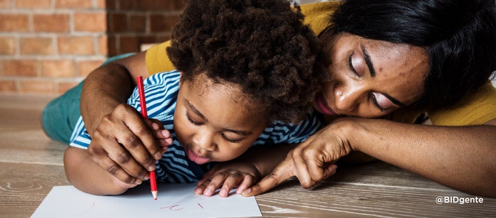 Madre e hijo de 5 años pintan juntos en un papel