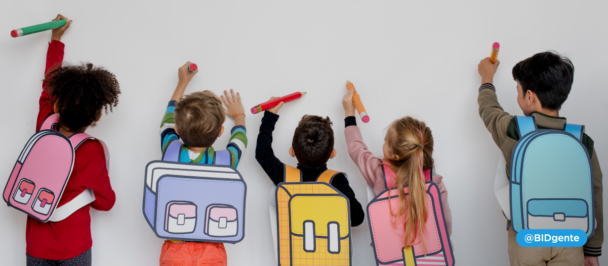 5 niños de 6 años con sus mochilas escriben en una pizarra