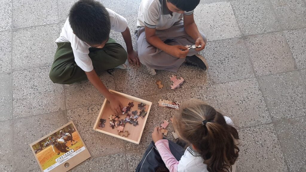 Un grupo de niños arman un puzzle