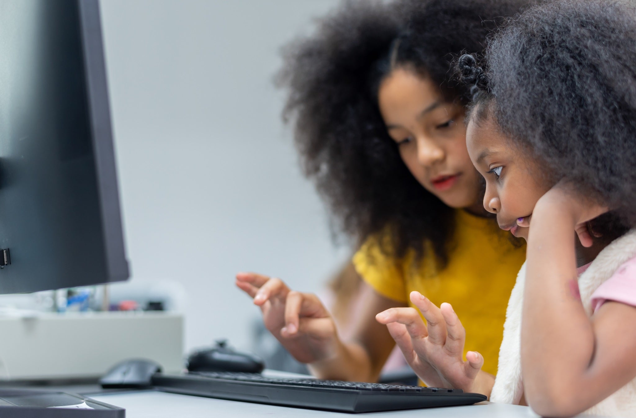 Dos niñas estudian en una computadora
