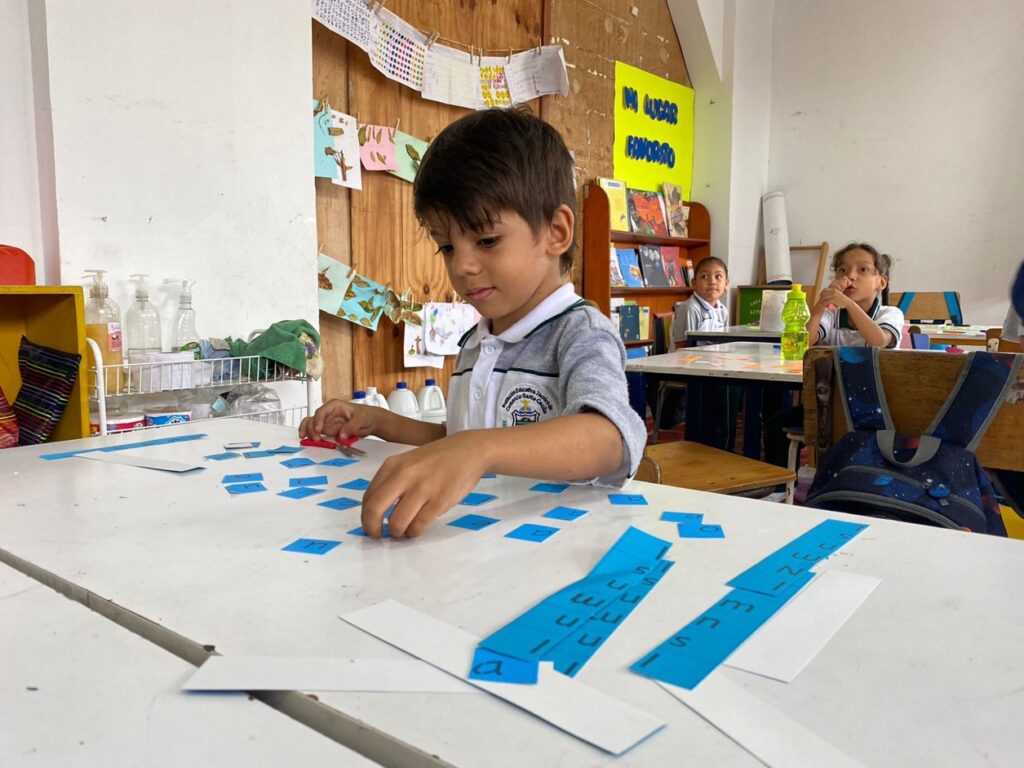 Niño en clase aprendiendo de lectura y escritura