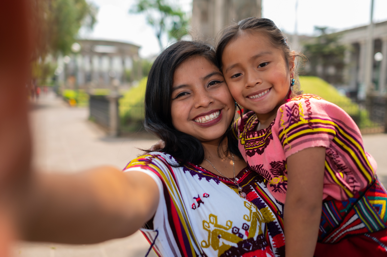 Joven y niña indígenas sonríen en un "selfie"