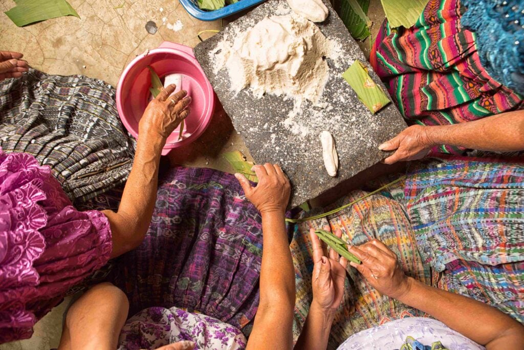Un grupo de mujeres rurales indígenas cocinan con métodos tradicionales.