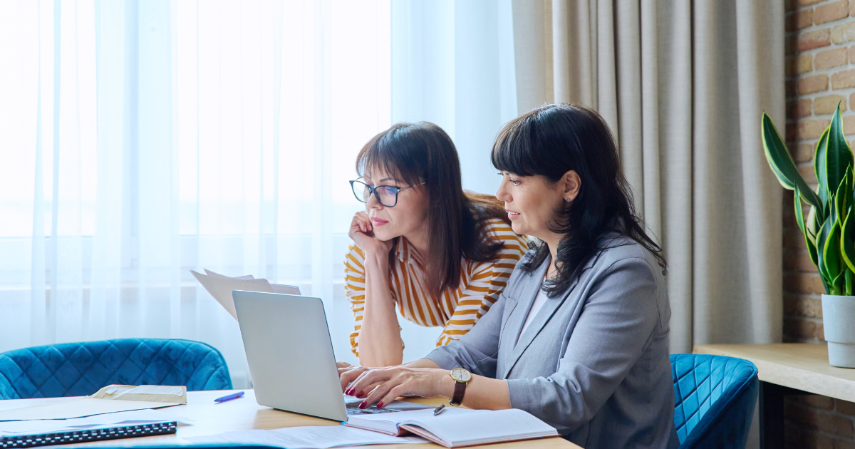 Dos mujeres de 50 años trabajando en una laptop