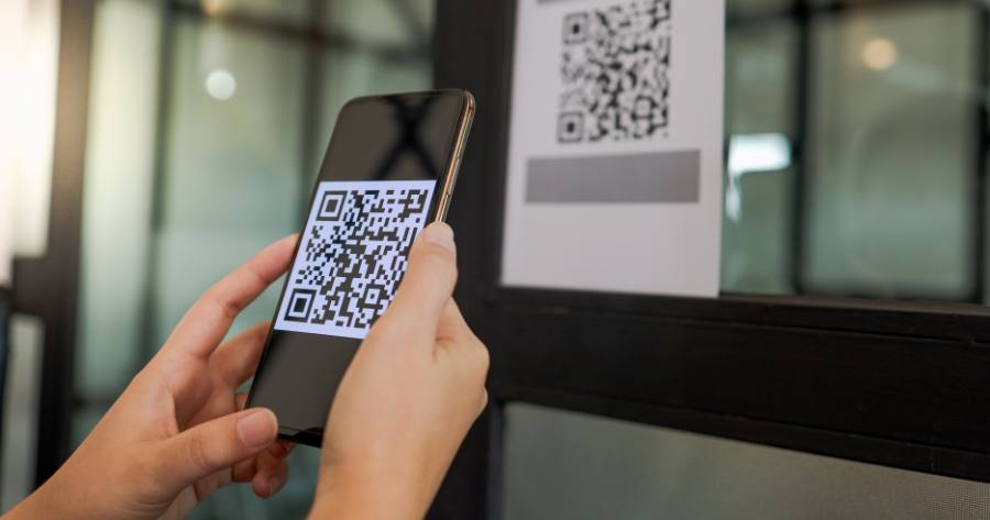 Persona con celular en sus manos mientras escanea un código QR