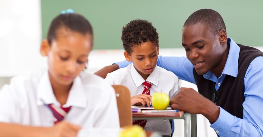 Male Afro-descendant teacher helps a student
