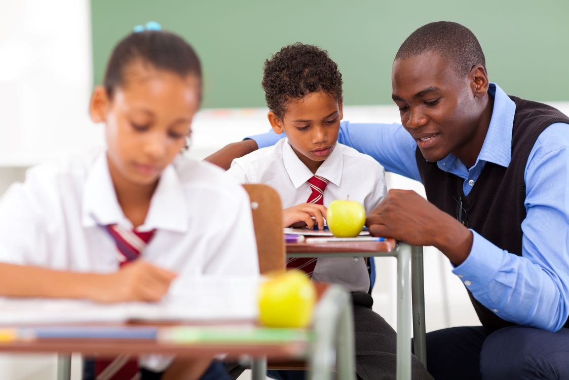Male Afro-descendant teacher helps a student