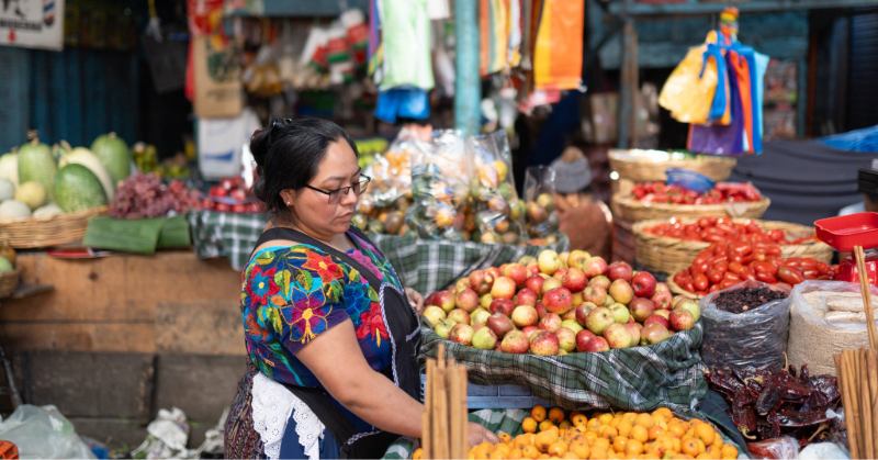 Mujer indígena guatemalteca vende frutas en un puesto ambulante