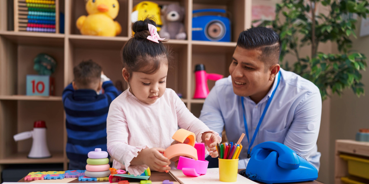Male teacher playing with a kindergarden student