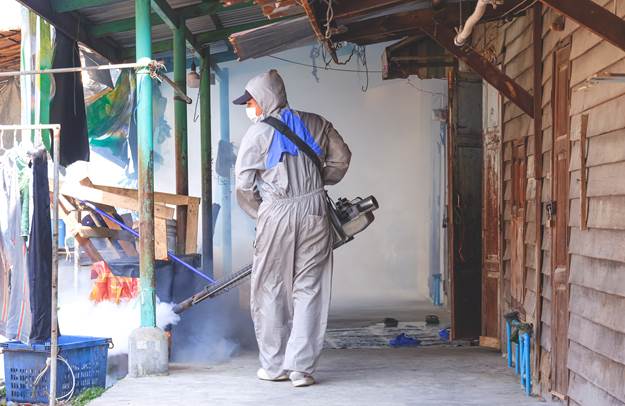Home fumigando com equipamento de proteçao