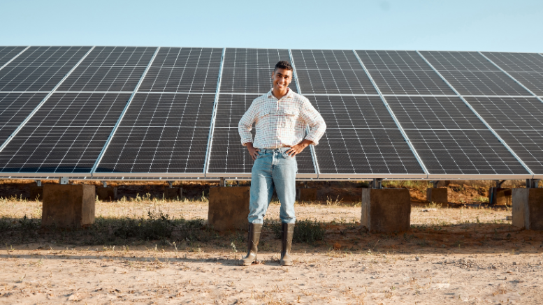 Un joven agricultor que sabe cómo mejorar sus cultivos con energía renovable a través de paneles solares como parte de su empleo verde