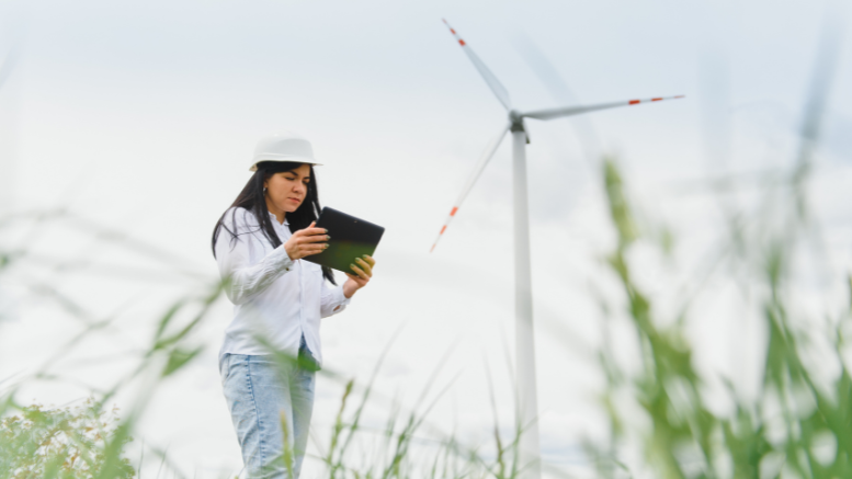 Una joven trabajadora analiza el funcionamiento de generadores de energía renovable en un campo como parte de su empleo verde